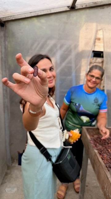 Myzo founder showcasing a dried cocoa bean with farmer
