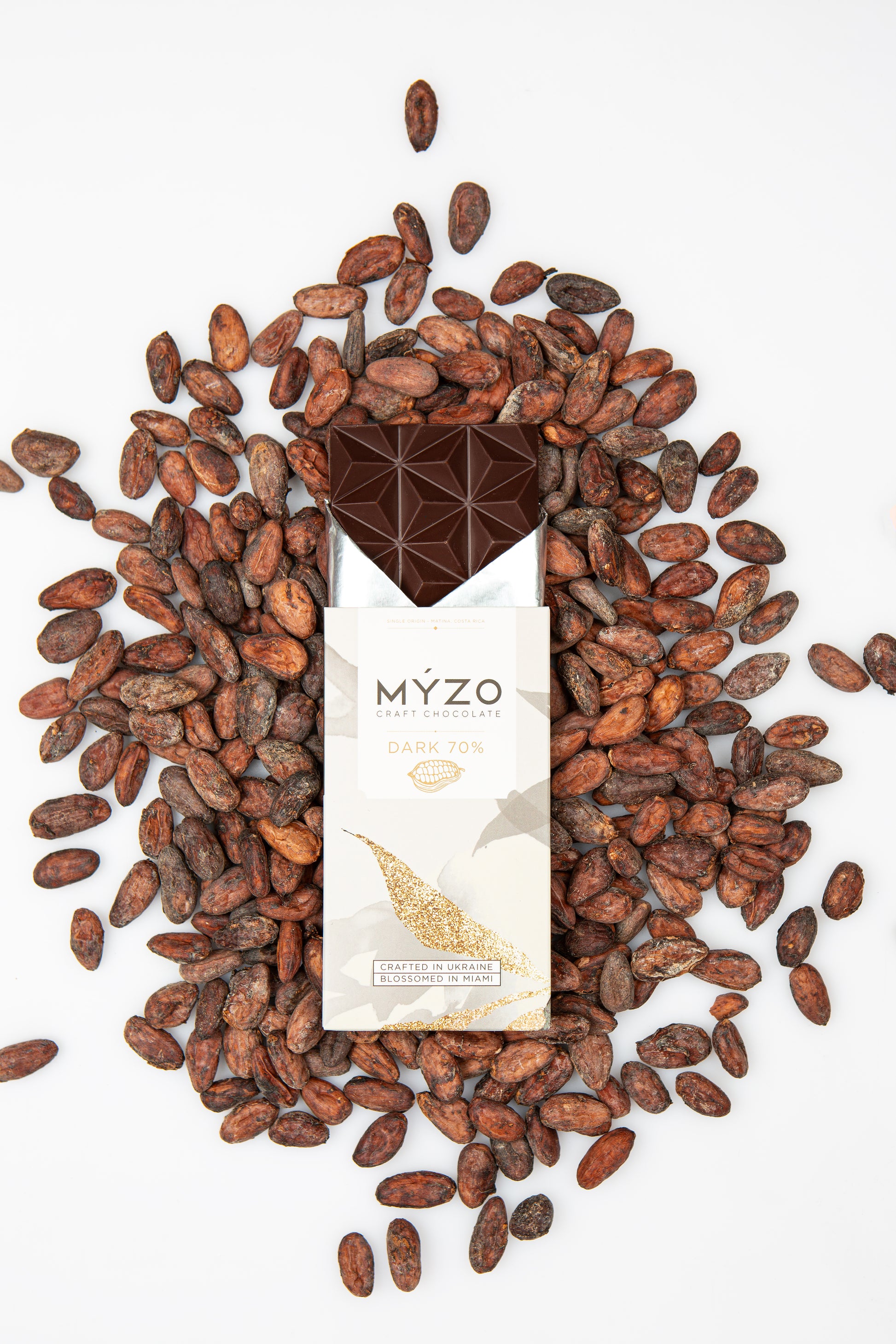 MYZO dark chocolate bar surrounded by raw Matina cacao beans from Costa Rica
